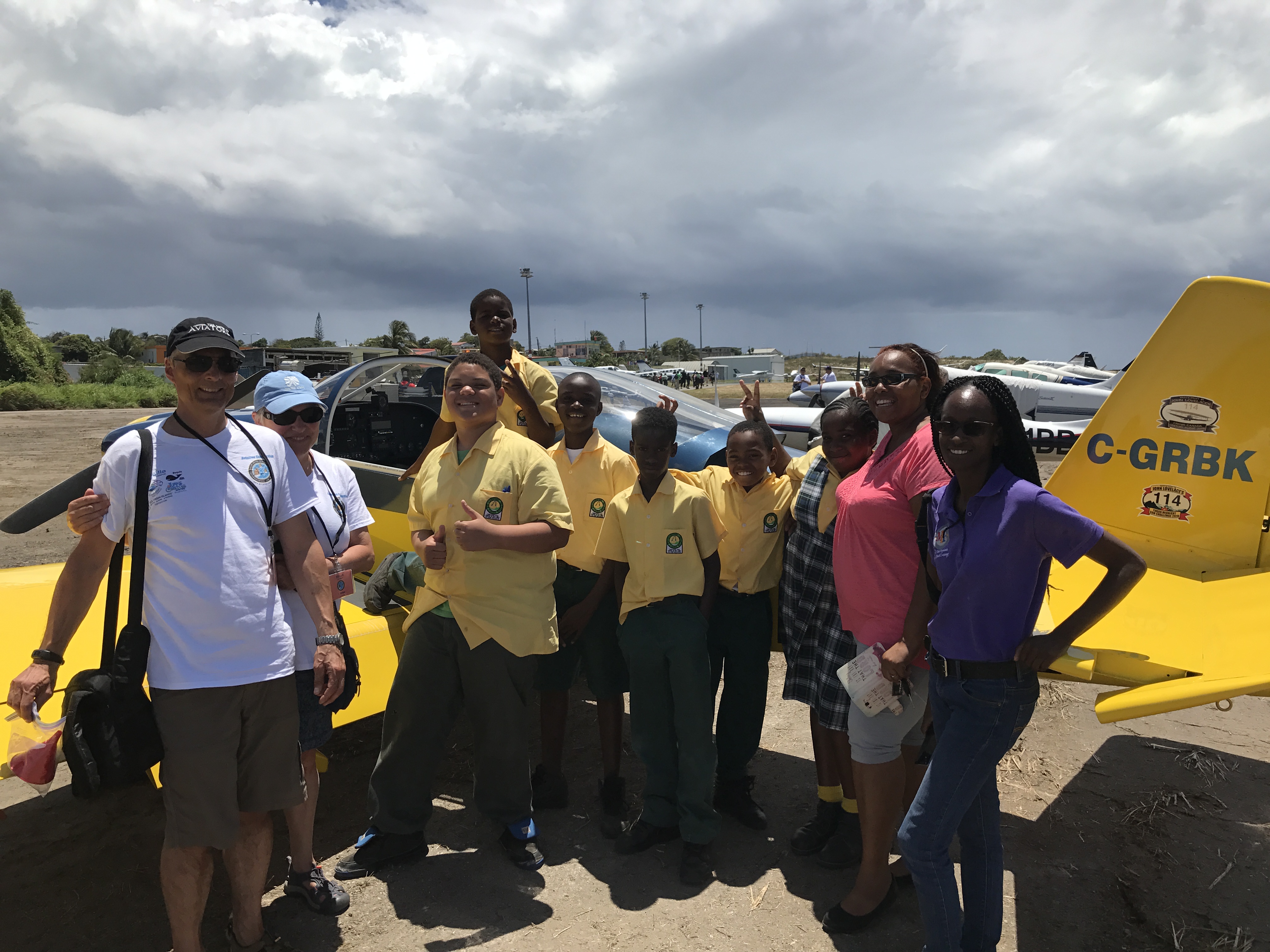 Local students posing with International Air Rally pilots and aircraft
